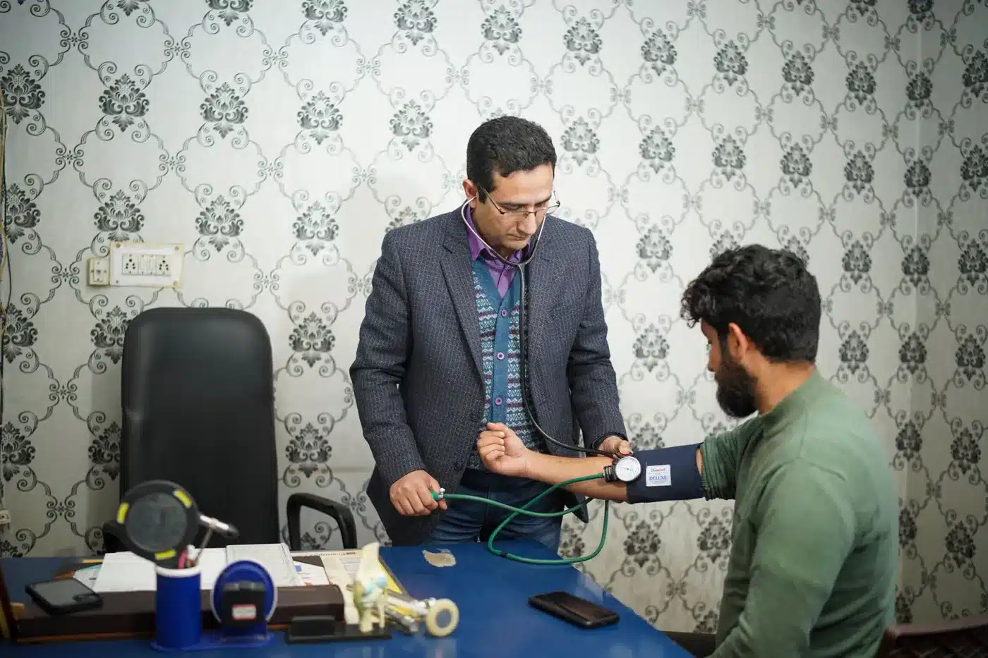 A doctor checking a patient's blood pressure during a consultation