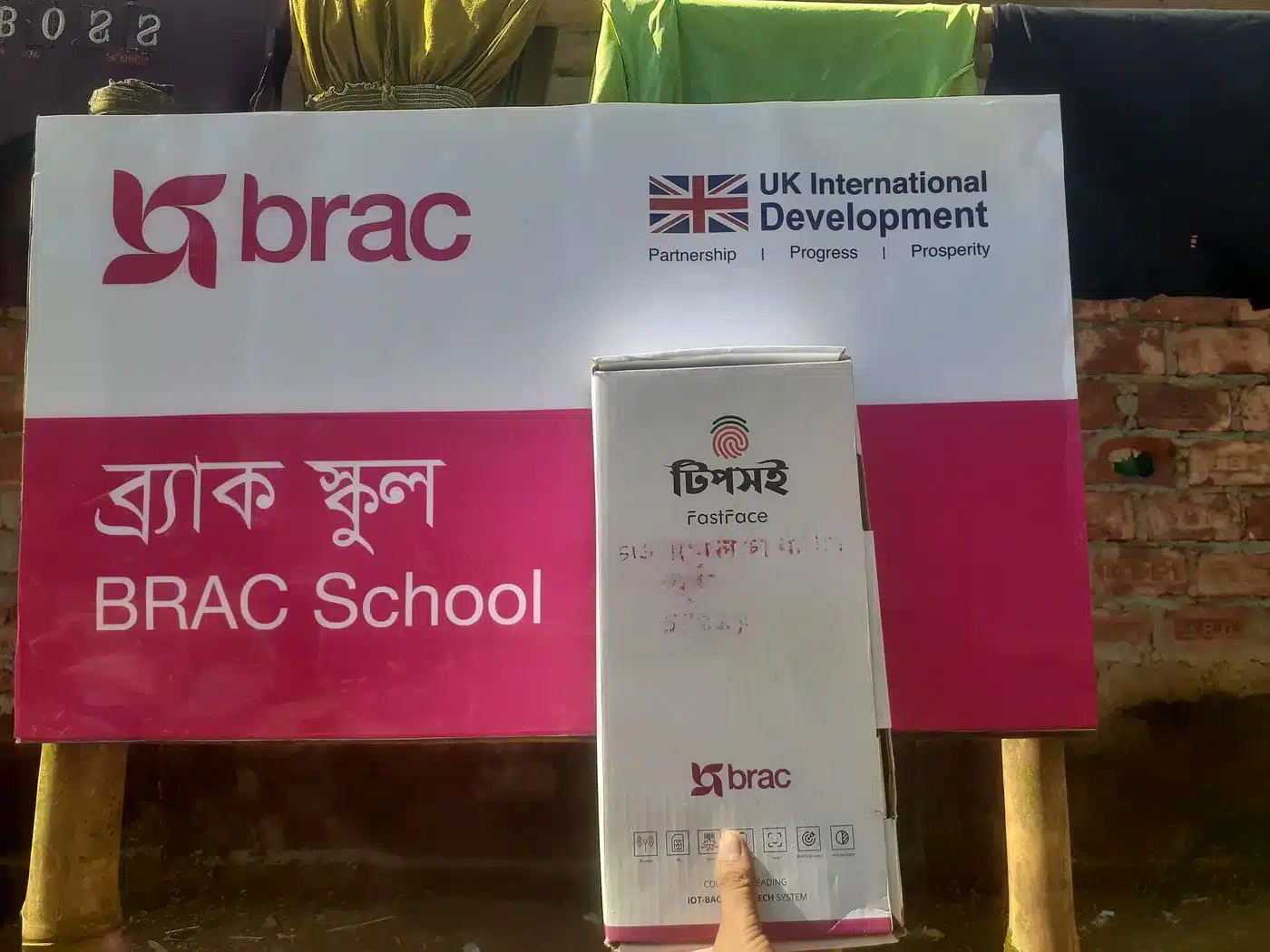 BRAC School sign with a boxed Tipsoi FastFace device held in front of it