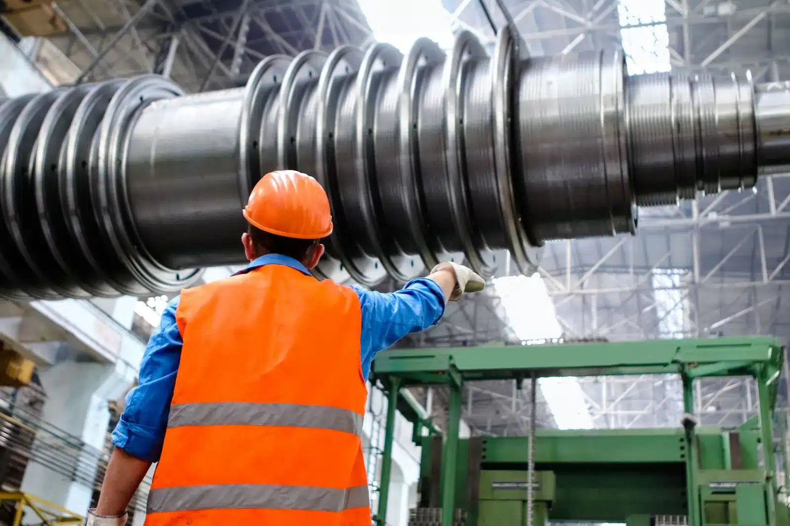 A worker in a safety vest inside an industrial plant